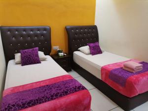 莎阿南莎阿南智慧城市米米拉拉酒店的两张睡床彼此相邻,位于一个房间里