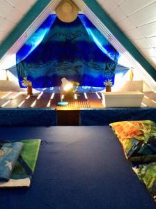 AfaahitiL'Auberge de Tahiti Iti - Beach hostel的阁楼间设有床和蓝天篷