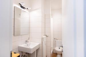 比勒费尔德CARICASA: Bielefeld Mitte的白色的浴室设有水槽和卫生间。