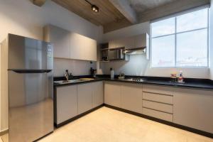墨西哥城P502 Rooftop views 33drm 2bath AC的一间厨房,配有白色的橱柜和大窗户