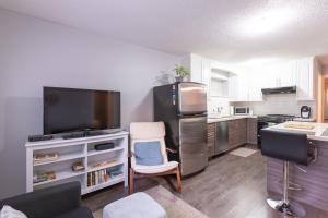 温哥华Suite Sunrise的厨房配有不锈钢冰箱和电视。
