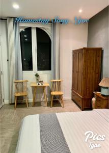 潘切Homestay Song Ngọc Phan Thiết的一间卧室配有一张床、两把椅子和一张桌子