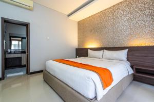 塞米亚克Casa Dasa Legian的一间卧室配有一张带橙色毯子的大床