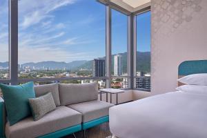 乔治市Penang Marriott Hotel的一间卧室配有一张床、一张沙发和窗户。