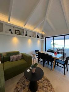 Saint BarthelemyAppartement 2 chambres en plein cœur de St Jean的客厅配有绿色沙发和桌子