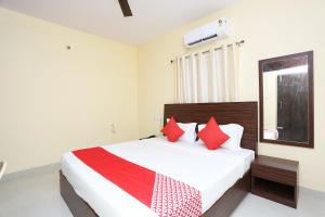 PānchagānSuper OYO Hotel The Green Akress的一间卧室配有一张带红色枕头的大床