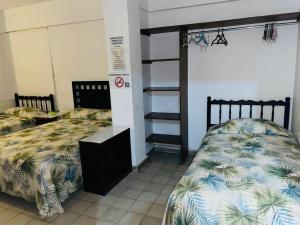 阿卡普尔科Hotel El Kiosco的一间卧室配有两张床和一张双层床。