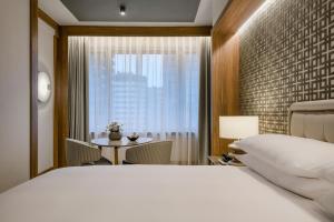 马德里库斯科万豪AC酒店的一间卧室配有一张床、一张桌子和一个窗户。