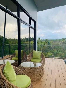 CavintiJinjer Resort的阳台配有藤椅和桌子,窗户