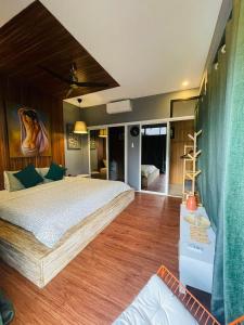 CavintiJinjer Resort的一间卧室设有一张大床,铺有木地板。
