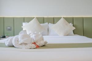 北碧米塔潘酒店的一张带毛巾和枕头的床