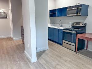 埃尔卡洪El Cajon Inn & Suites的厨房配有蓝色橱柜、水槽和微波炉