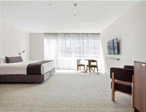 堪培拉Abode Phillip的酒店客房配有一张床铺和一张桌子。