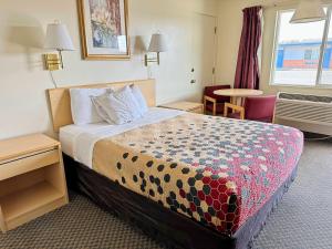 BoardmanRodeway Inn Boardman - Hermiston的酒店客房配有一张床铺和一张桌子。