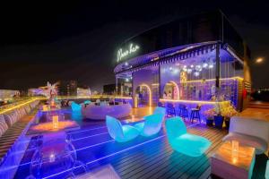 清迈Moose Hotel Nimman的屋顶酒吧在晚上提供蓝色的椅子和桌子