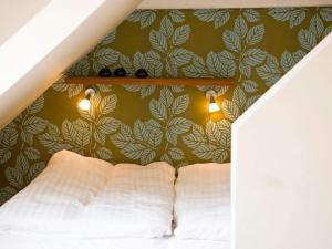 斯瓦讷克3 person holiday home in Svaneke的一间卧室配有一张带绿色墙壁的床