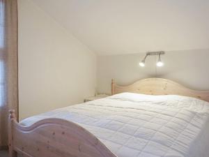 王室港6 person holiday home in KUNGSHAMN的一间卧室配有一张带白色床单的大床