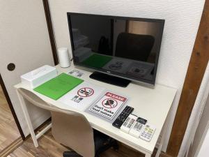 大阪TSUBAME 101 staying private home的桌子上方的桌子上装有电脑显示器