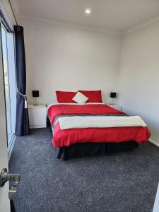 NorsewoodOasis Rural Retreat的一间卧室设有红色的床和窗户。