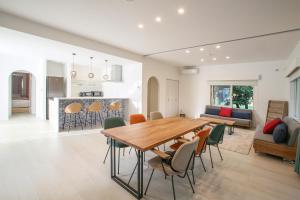 石垣岛アイニクル -Create Future Community-的用餐室以及带木桌和椅子的客厅。