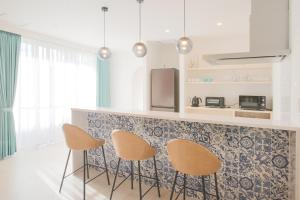 石垣岛アイニクル -Create Future Community-的厨房配有三把椅子和台面