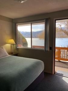 奥索尤斯阳光海滩汽车旅馆的一间卧室配有一张床,享有湖景
