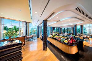 海得拉巴ITC Kohenur, a Luxury Collection Hotel, Hyderabad的用餐室配有餐桌和食物