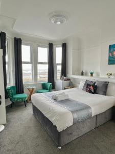 滨海绍森德Wns Southend -on-Sea的一间卧室配有一张大床和两张绿色椅子