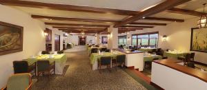 派帕派帕公约中心Spa酒店的用餐室配有绿色的桌椅