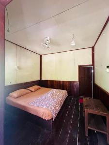 Muang KhôngJungle Bangalow Don Det的一间卧室配有一张床,铺有木地板