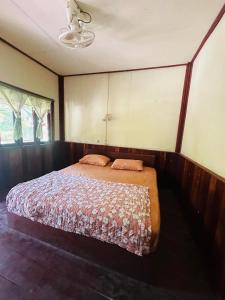 Muang KhôngJungle Bangalow Don Det的卧室位于客房的角落,配有一张床