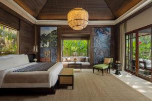 乌布Mandapa, a Ritz-Carlton Reserve的度假村的卧室配有床和吊灯