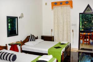 安帕赖Terrel Residencies Gal Oya的一间卧室设有两张床和一个带桌子的窗户。