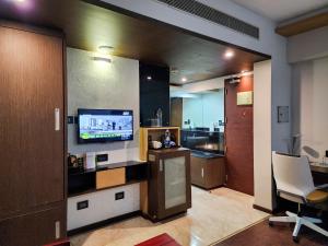 特里凡得琅Dimora Hotels And Resorts的带电视的客厅和厨房