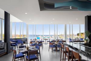 桑德贝Delta Hotels by Marriott Thunder Bay的一间带桌椅并享有水景的餐厅