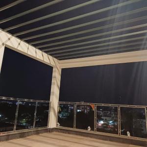 德奥加尔Hotel Taj Akash的阳台,晚上可欣赏到城市景观