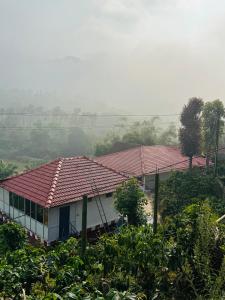 马迪凯里Coorg Heritage Hill View Resort的山坡上一座红色屋顶的房子