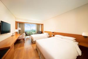 西归浦市济州岛WE酒店的酒店客房设有两张床和电视。