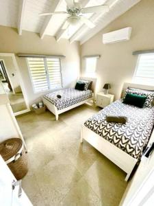 辛普森湾New* Tropical Modern Townhouse in SXM的一间卧室设有两张床和天花板