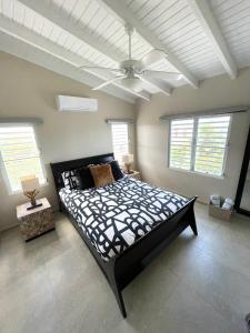 辛普森湾New* Tropical Modern Townhouse in SXM的一间卧室配有一张大床和吊扇