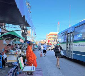 Ban Lam Riห้องพักสบาย เป็นส่วนตัวในบ้านเรือนไทยที่ตอบโจทย์ความต้องการ的站在公共汽车旁的橙色长袍上的人