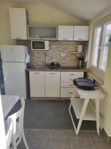 拉斯托伏Apartment Brezak的厨房配有白色橱柜、桌子和水槽。