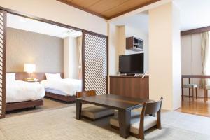 富士河口湖Kawaguchiko Park Hotel的酒店客房设有一张床铺、一张桌子和一间卧室。