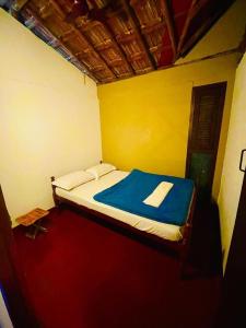 卡尔佩特塔Oryza wayanad的小卧室配有一张带蓝色毯子的床