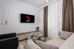 里耶卡Area Luxury Spa Apartment的客厅配有沙发和墙上的电视