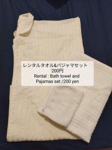 宇都宫セルフチェックイン Guest House SHUKUGO UTSUNOMIYA的上面有标志的白色毛巾