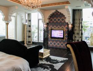 宜兰市欧游连锁精品旅馆-宜兰馆的一间卧室配有一张床,并在一间客房内配有电视。