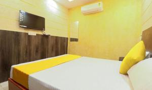 瓜廖尔FabHotel Rama Inn I的卧室配有一张床,墙上配有电视。
