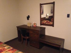 SchreiberVilla Bianca Inn的一间卧室配有书桌、镜子和床