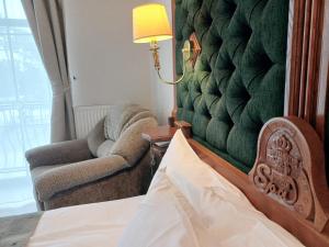 尤尔马拉佩嘎萨必尔斯温泉酒店的一间卧室配有一张床、一把椅子和一盏灯